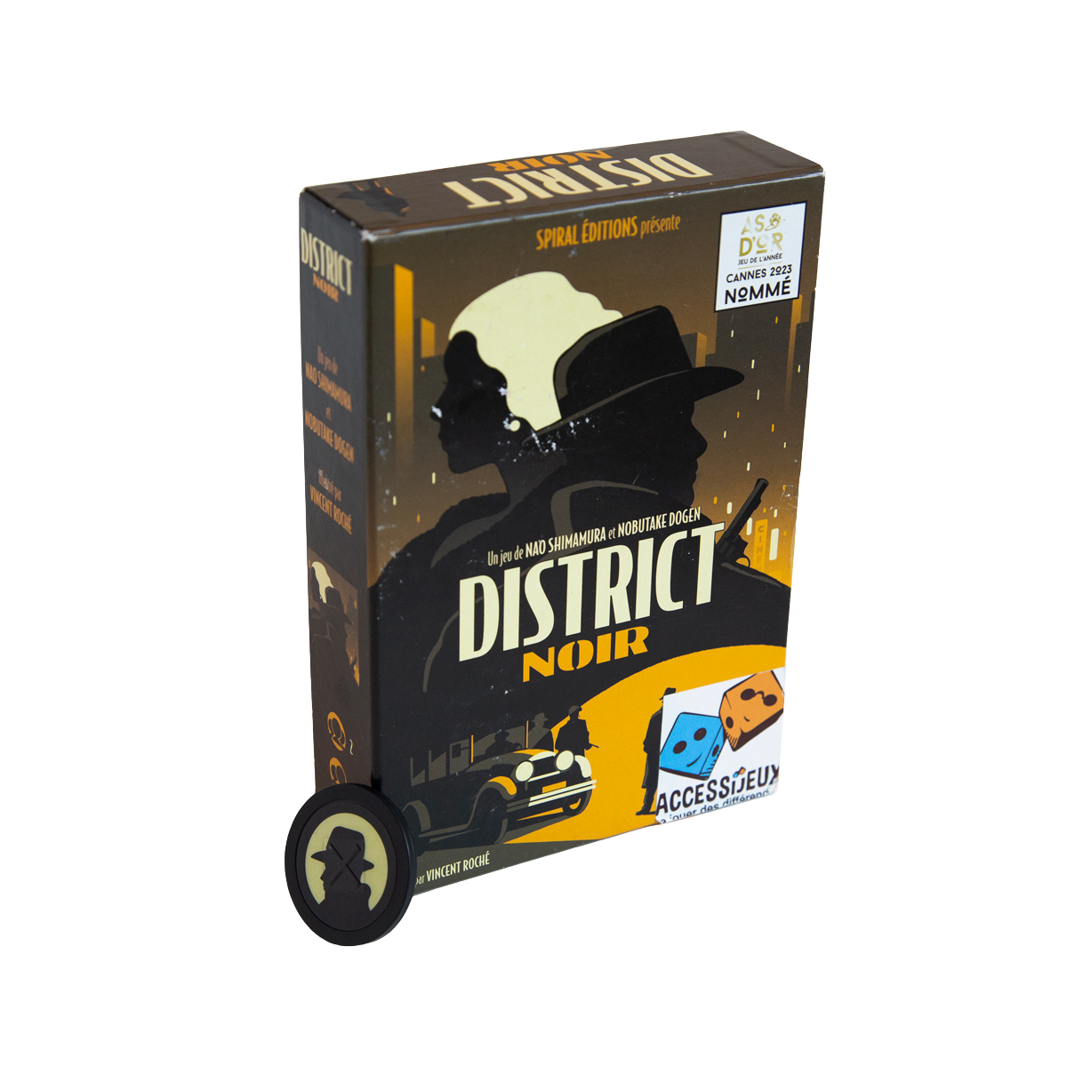Une boîte de District noir avec une illustration représentant un détective, une voiture ancienne et un paysage urbain sur le thème du roman noir. Devant la boîte se trouve un jeton rond District noir représentant la silhouette d'un détective.